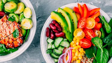 Zwei Bowls mit frischem Gemüse, darunter Avocado, Tomaten, Gurken, Spinat, Paprika, Mais, Bohnen und Hähnchen vom Foodservice